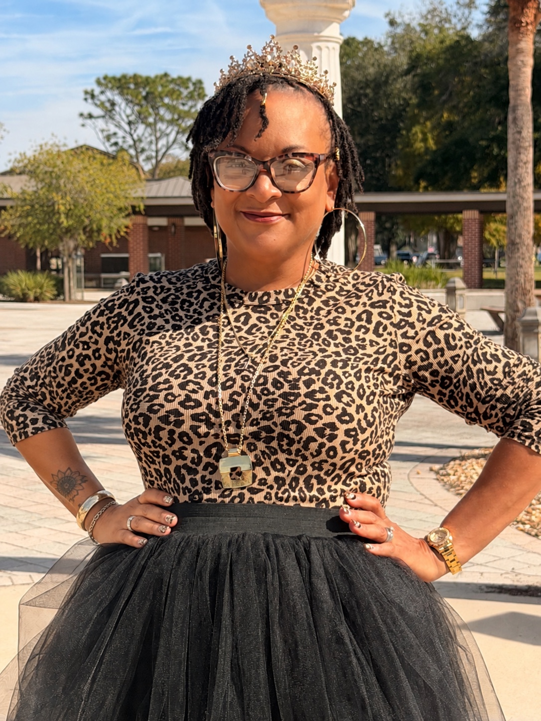Dr. Iana L. Harris wearing a crown and glasses outdoors